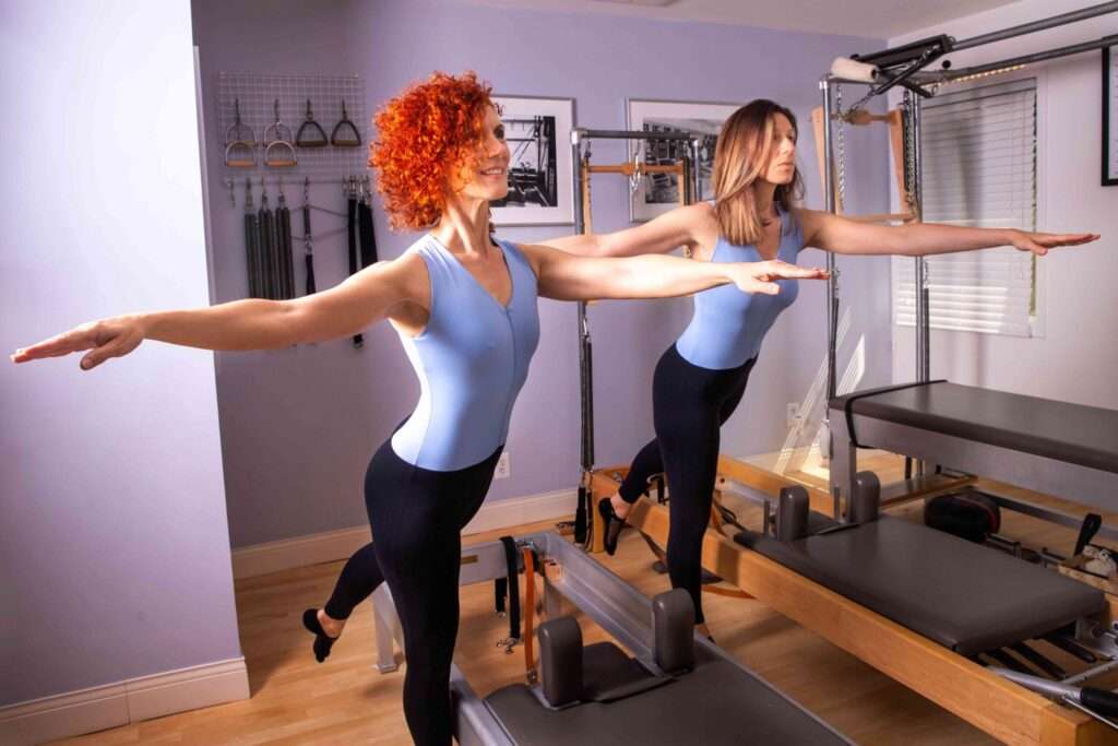 Instructors Vivian and Chrissy demonstrating our studio's Pilates equipment